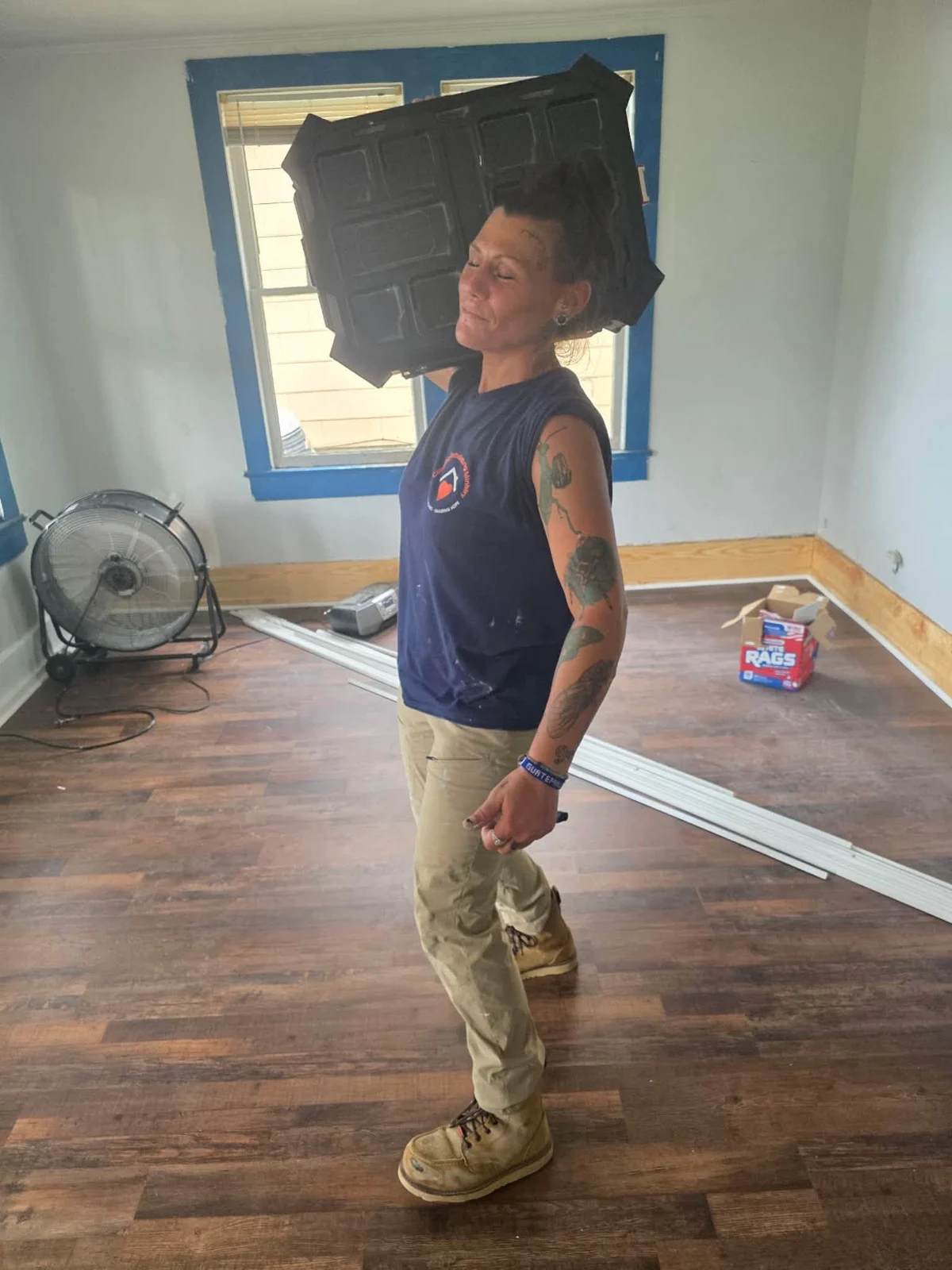 A volunteer carrying materials inside a home