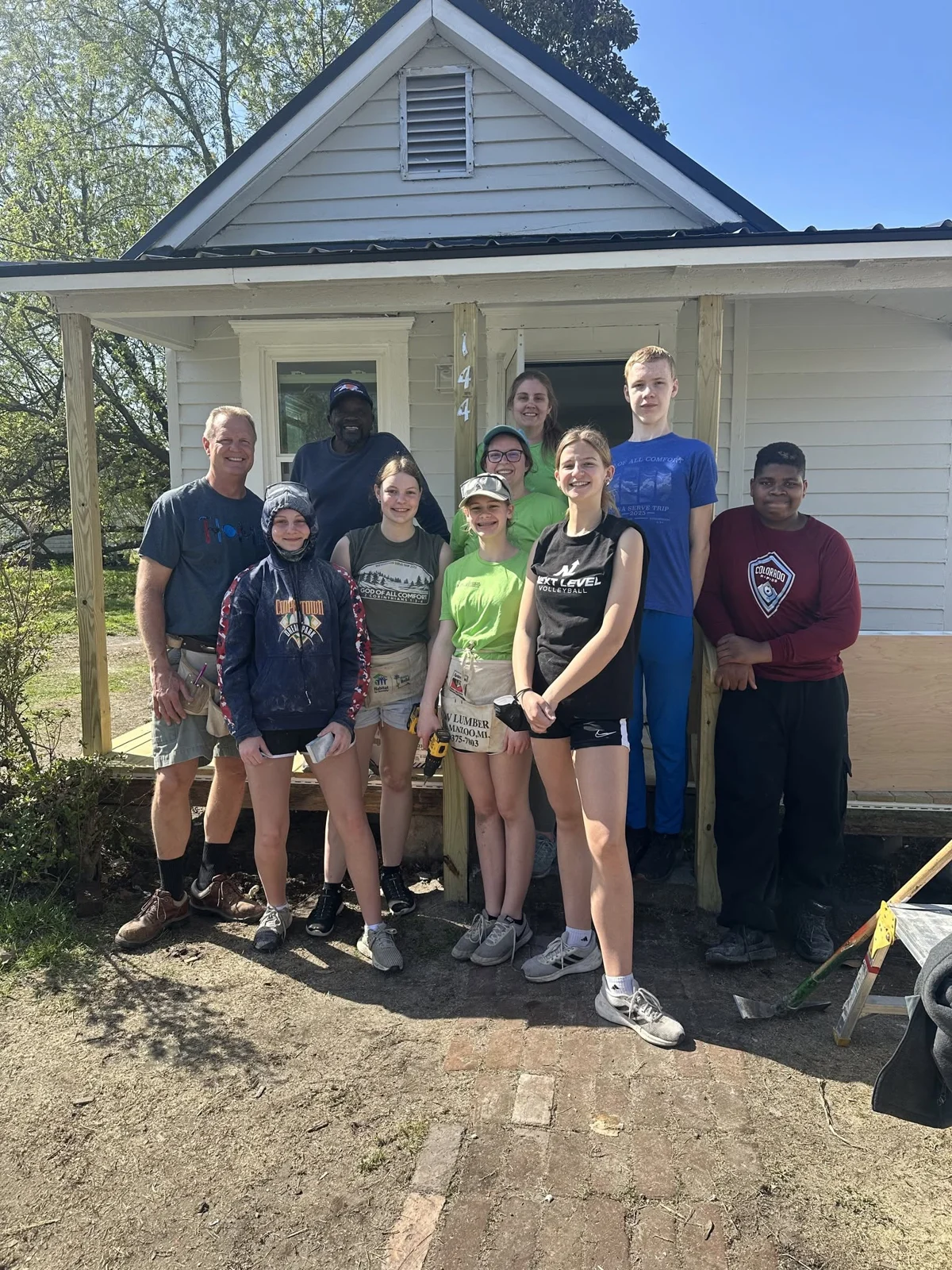 A CRM volunteer team gathered outside a home